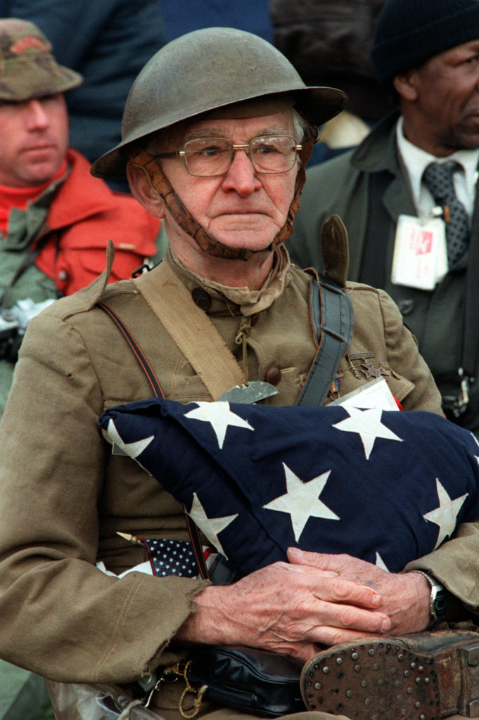 1982-11-13, Washington DC.  Joseph Ambrose, an 86-year-old World War I veteran, attends the dedication day parade for the Vietnam Veterans Memorial in 1982.  He is holding the flag that covered the casket of his son, who was killed in the Korean War.  Photo is in the public domain (https://commons.wikimedia.org/wiki/File:Veterans_day.jpg).